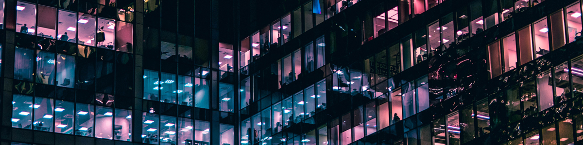 Windows in a tall building lit at night. Photo by Mike Kononov on Unsplash